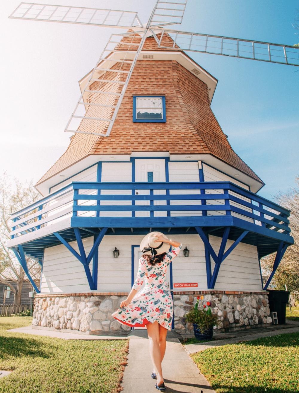 A visitor looks upwards towards the blades of The Dutch Windmill Museum in Beaumont, TX.