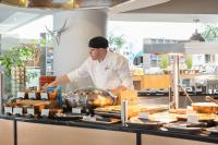 White man in chef's whites behind a counter of food at Hilton Cambridge City Centre hotel