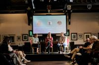 Three speakers discussing with their audience as part of a conference