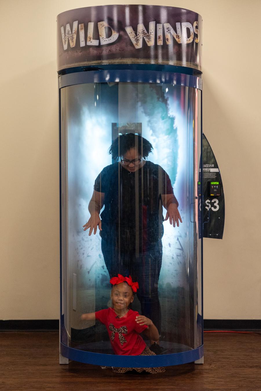 Mother and her daughter in the tornado simulation tube at Imagination Place.