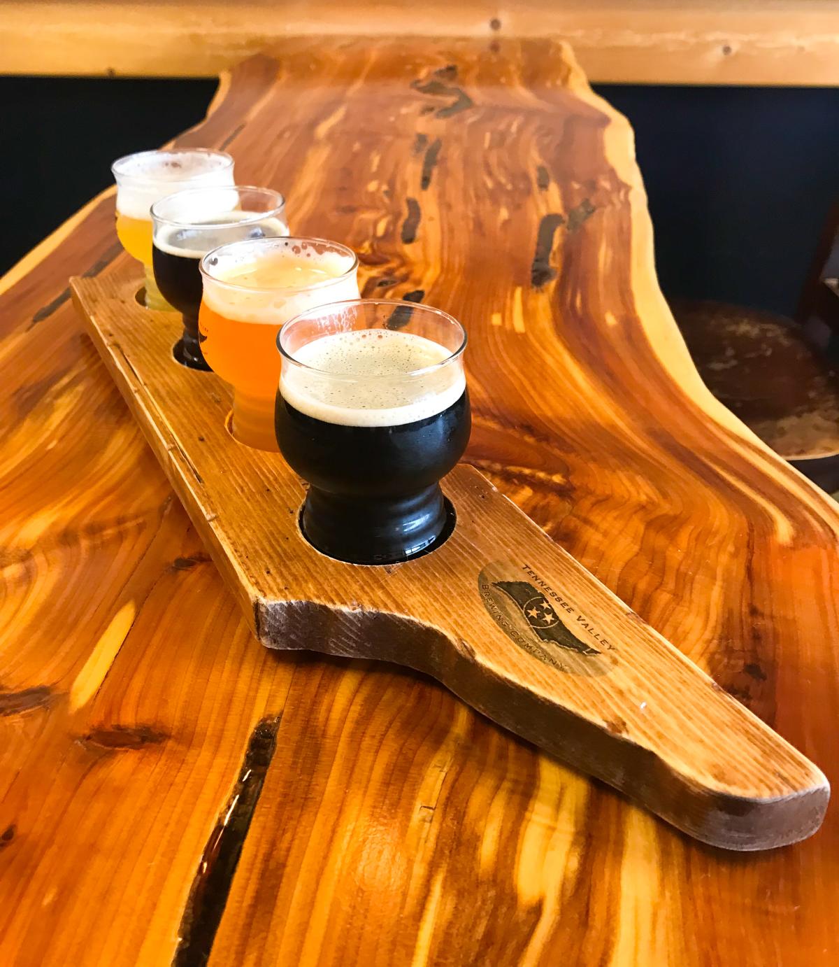 flight of four beers in a wooden cutout of TN
