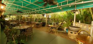Landy's Restaurant outdoor dining patio with tables, chairs, canopy cover, and greenery