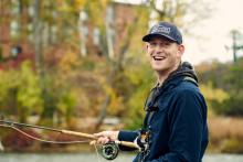 Tom Carton smiling and fishing