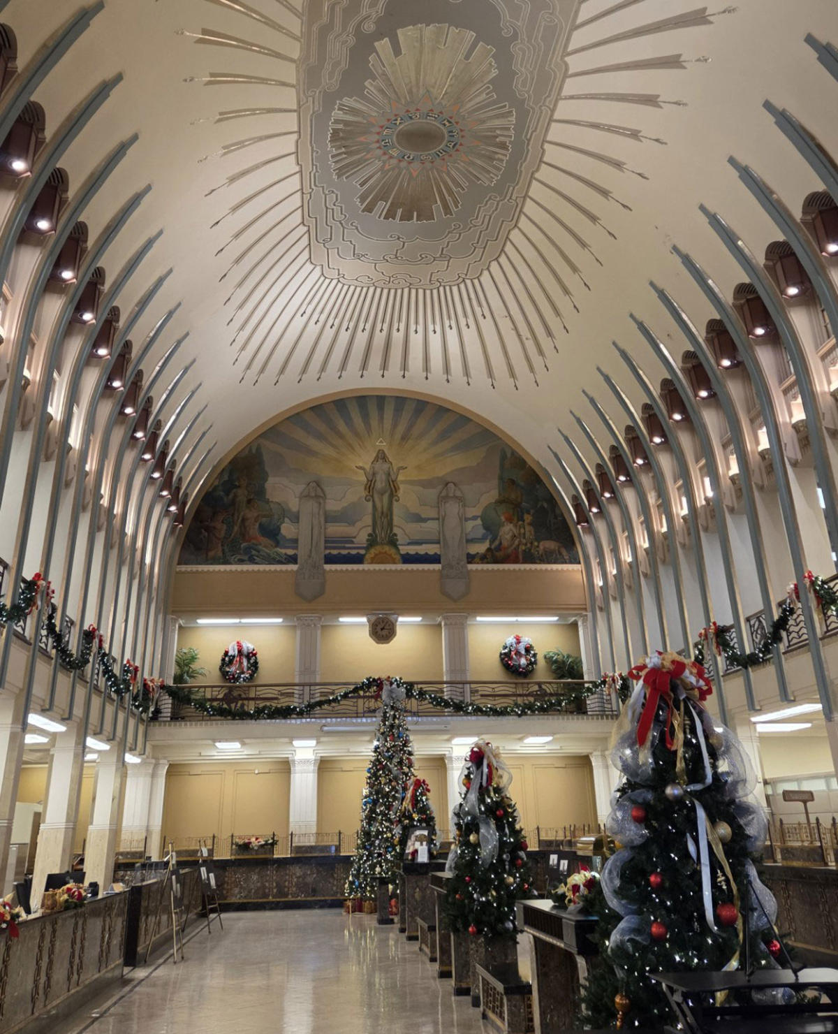 The bank room in the Lincoln Tower features a high domed ceiling ceiling with murals, marble counters, and impressive pillars