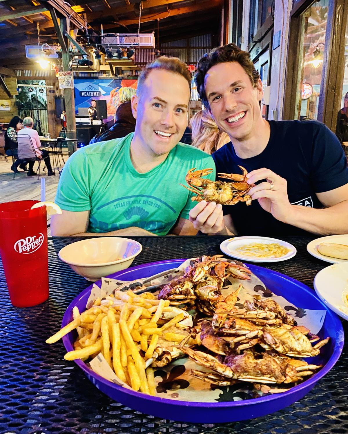 Two Guys Holding A Crab At Crazy Cajun In Beaumont, TX