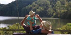 Vagabond 3 World Travel Blogger sitting with husband and toddler looking over the Bull Sluice Lake at Morgan Falls Park in Sandy Springs, GA