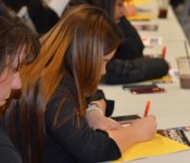 A woman jots down notes on a yellow sheet of paper during the March 2018 Industry Insider Training