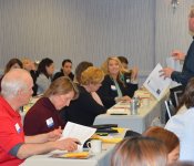 A man holds up a sheet of paper while presenting at the March 2018 Industry Insider Training