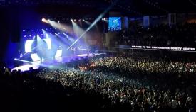 A crowd cheers during a concert performance. 
