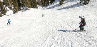 Three kids skiing down a mountain