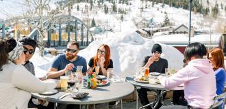 Group of friends eating at bridge on the patio on a spring day apres ski