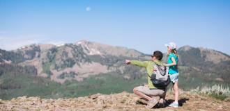 Father and young daughter looking at view from top of mountain