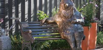 A statue of a bear on a bench on Main Street in Park City, UT