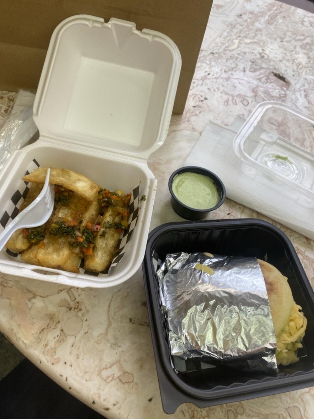 Two containers from Arepas El Pana that contains an arepa and yucca fries.