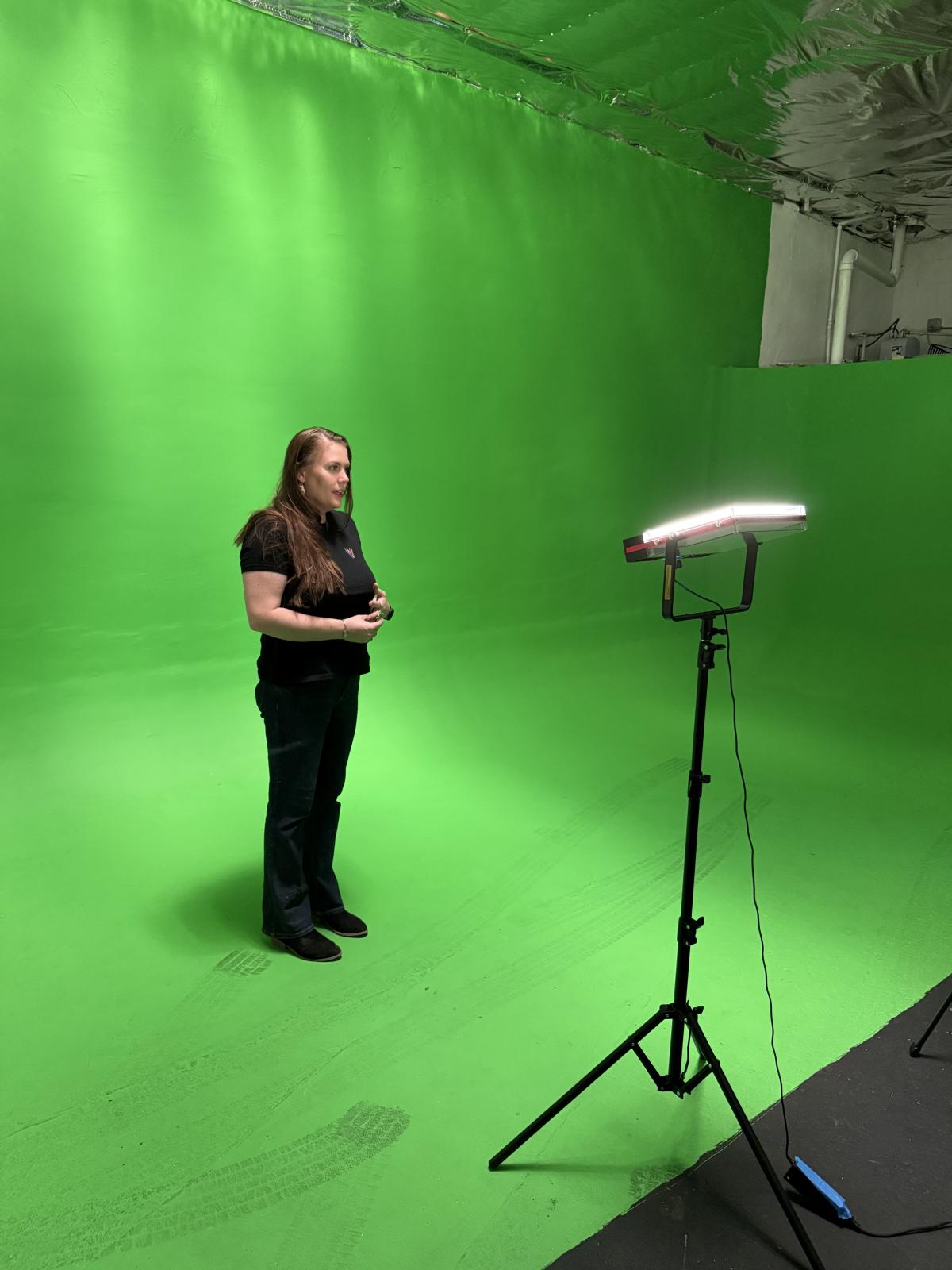 Kat Bloom stands in the green screen bay at Vault Studios.