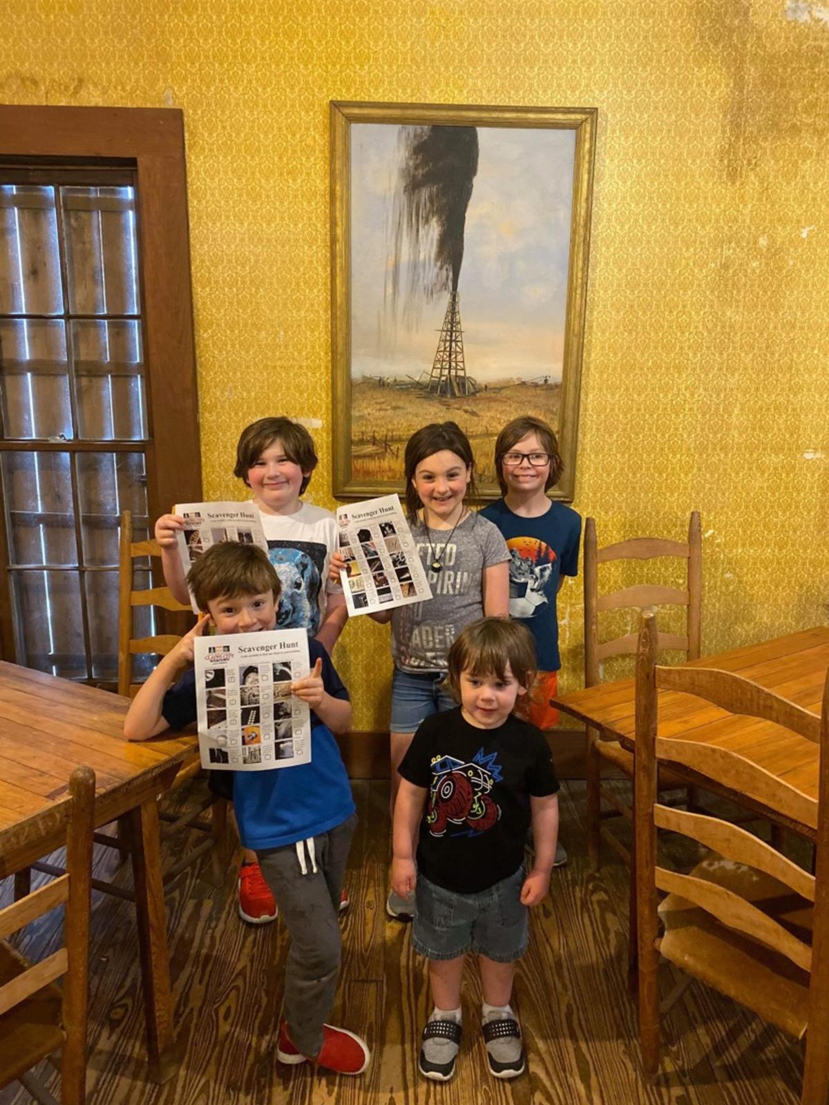 Kids holding up the Spindletop Scavenger Hunt sheet