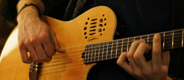 Close up of hands playing a guitar