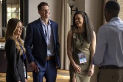 Two business women and two business men standing up, conversing