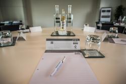 Moller Institute Cambridge: meeting room with pen & paper on table plus bottles of water & glasses