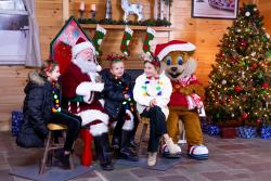 Picture of kids sitting with Santa & Cosmo at a Nickle Plate Bar & Grill Christmas Village event.