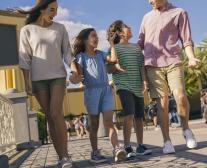 An hispanic family walking in a theme park.