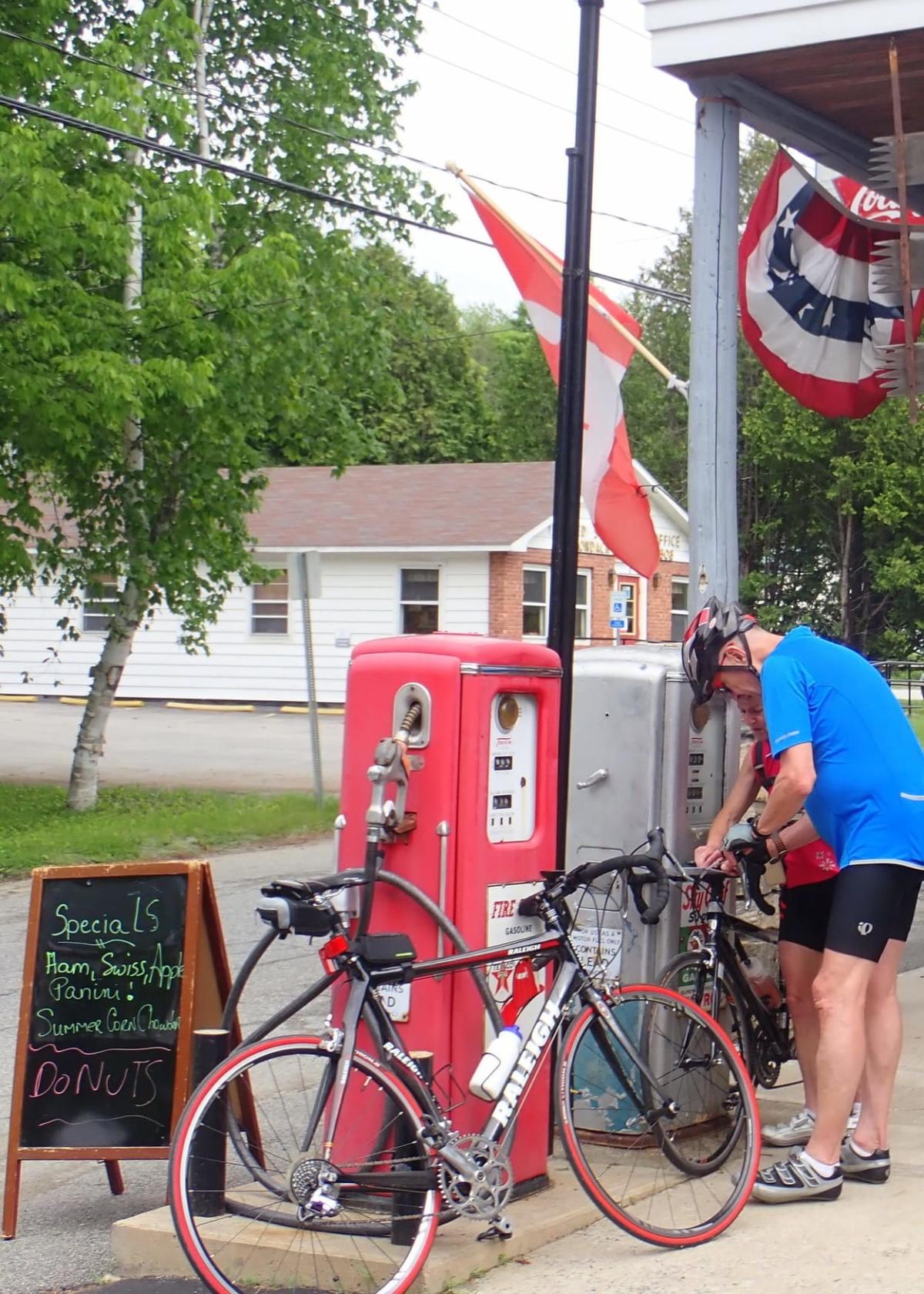 man with his bike next to the gas pumps at the Adirondack General Store in Schroon Lake