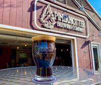 Picture of Pineknotter Brewing Co Sign with a pint of beer in a glass on a table