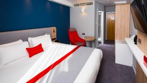 One of the bedrooms at Holiday Inn Express Burton upon Trent, Staffordshire, showing the bed, plasma screen TV and other furnishings
