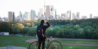 A person looks at the Toronto skyline from Riverdale Park in Toronto's east end