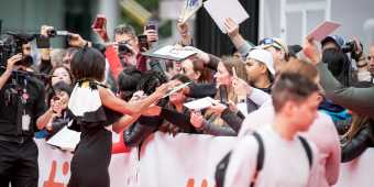 An actress signs autographs for fans at the Toronto International Film Festival