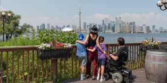 A family looks at the view of the Toronto skyline from Centre Island in summer
