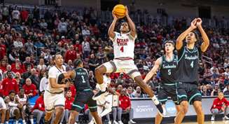 A college basketball player jumps to shoot a ball during a NCAA Men's Basketball tournament game at INTRUST Bank Arena.
