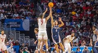 Two college players jump to get control of a basketball during a NCAA Men's Basketball Tournament game at INTRUST Bank Arena.