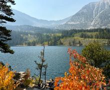 A view of Rock Creek Lake with patches of fall color orange in the frame.