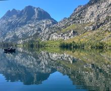 a boat on the water at Silver Lake, with a backdrop green and yellow aspen and Carson Peak