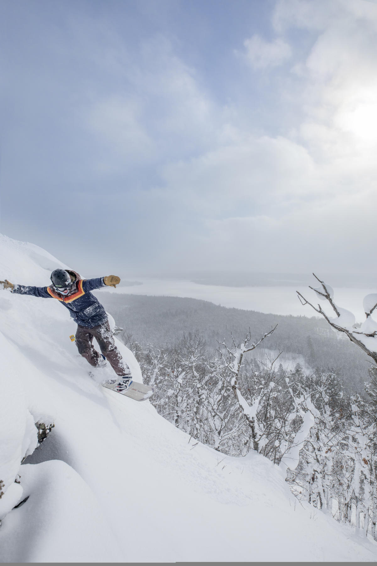Snowboarder gliding down mountain side