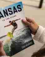 Woman holds a Kansas travel guide