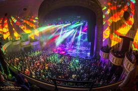 The Capitol Theatre during a concert alight with yellow, red and aqua colored lights.