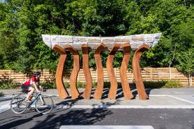 A biker rides past an art installation along The Bridge Path.