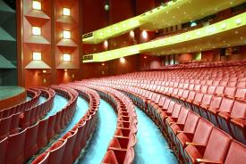 Inside seating view of one of the theaters at the Performing Arts Center with red seats and two balconies.