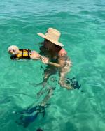 Woman swimming with her dog at Shell Island in Panama City Beach