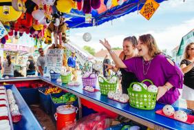 Two women play a game at the York Fair.