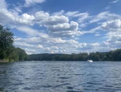 beautiful blue skies full of fluffy clouds over the Susquehanna River with a boat on the water in the distance