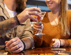 Picture of couple sitting with raised glasses "cheers" at Penn's Tavern