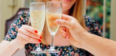 Two champagne flutes being held together in the air