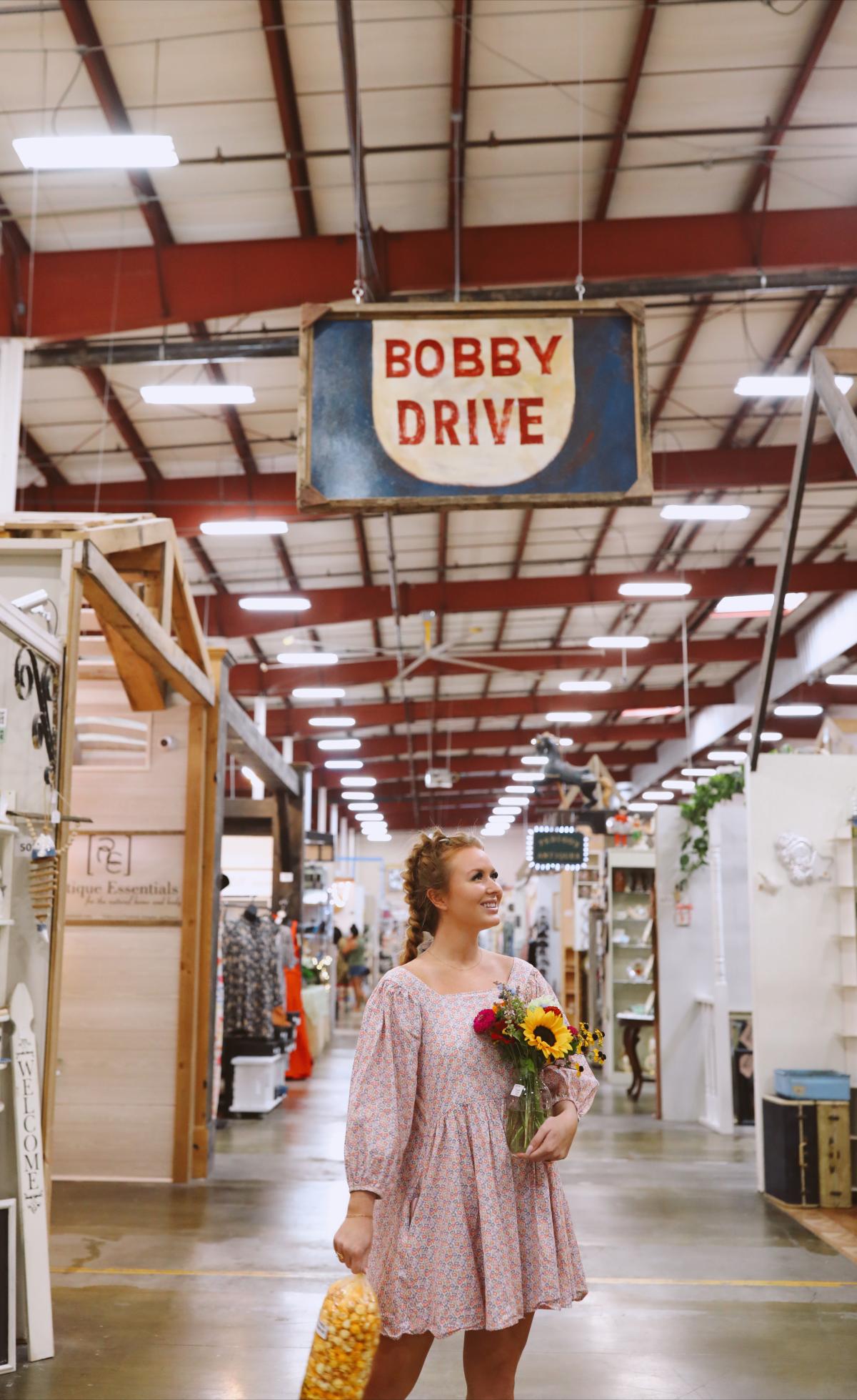 woman stands in aisle of shopping warehouse