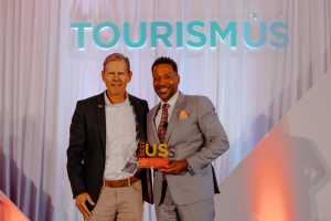 Columbus Zoo and Aquarium representative accepting the 2023 Corporate Businesses & Attractions Tourism Champion award at TourismUS