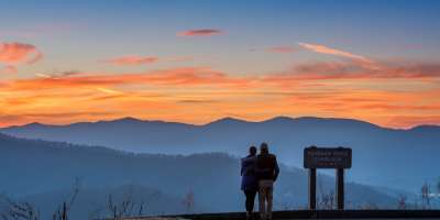 A couple enjoys a mountain vista on the Blue Ridge Parkway near Asheville, NC