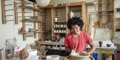 Ceramic artist Tristan Glosby works at the pottery wheel at Clayspace Co-op in the River Arts District of Asheville, North Carolina.