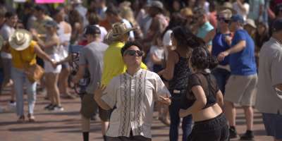 Two people dancing in crowd at Hola Asheville festival in downtown Asheville